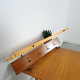 Vintage wall coat rack with black hooks and light wood