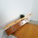 Vintage wall coat rack with black hooks and light wood