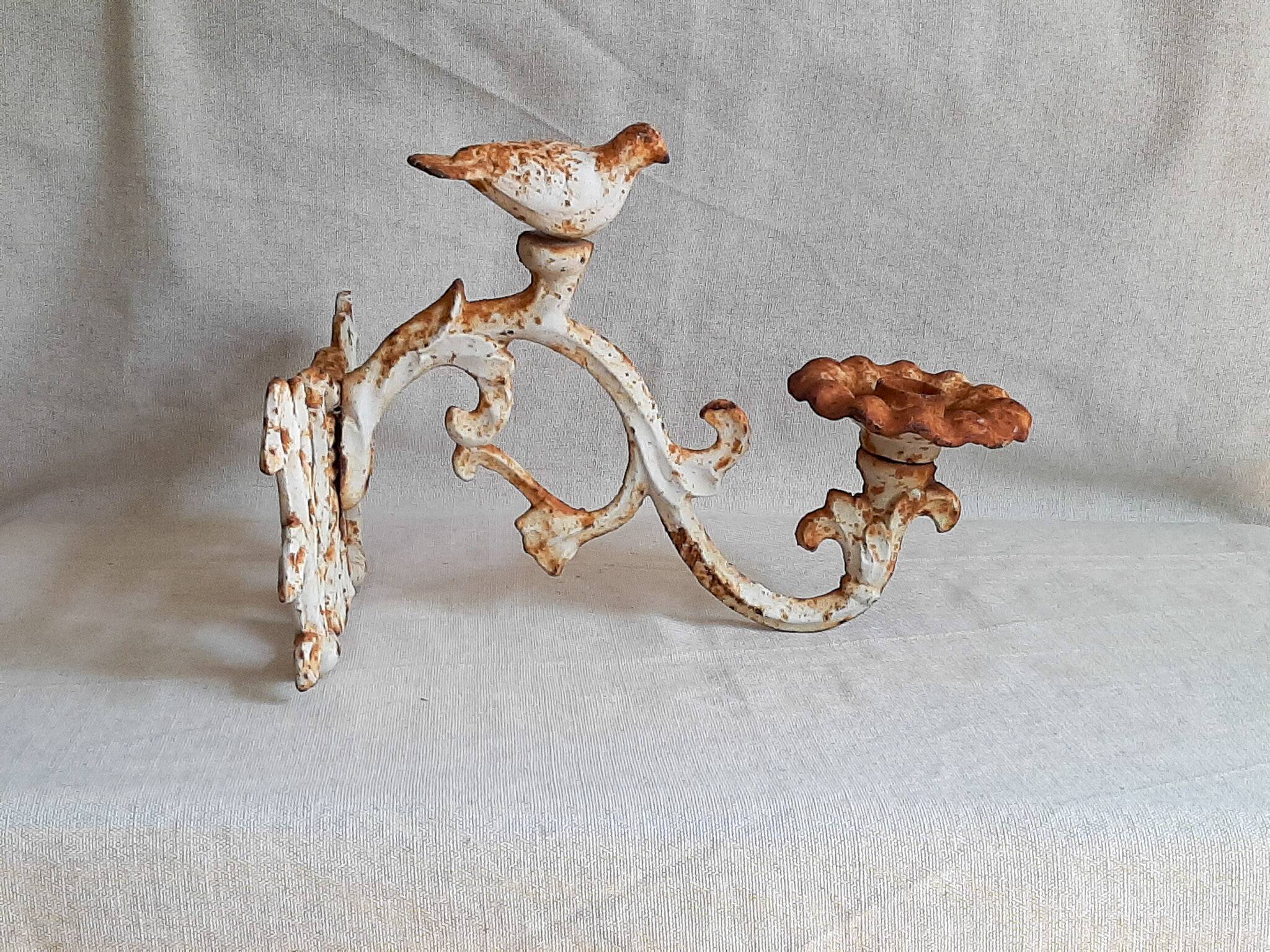 Wall lamp in antique cast iron with bird and scroll decorations.