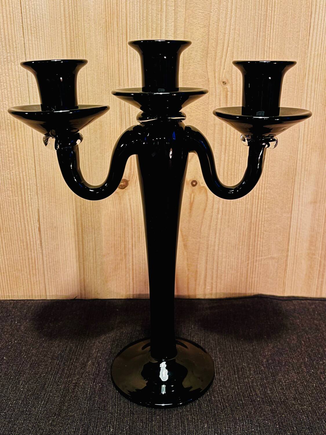 Set of four black glass candle holders.