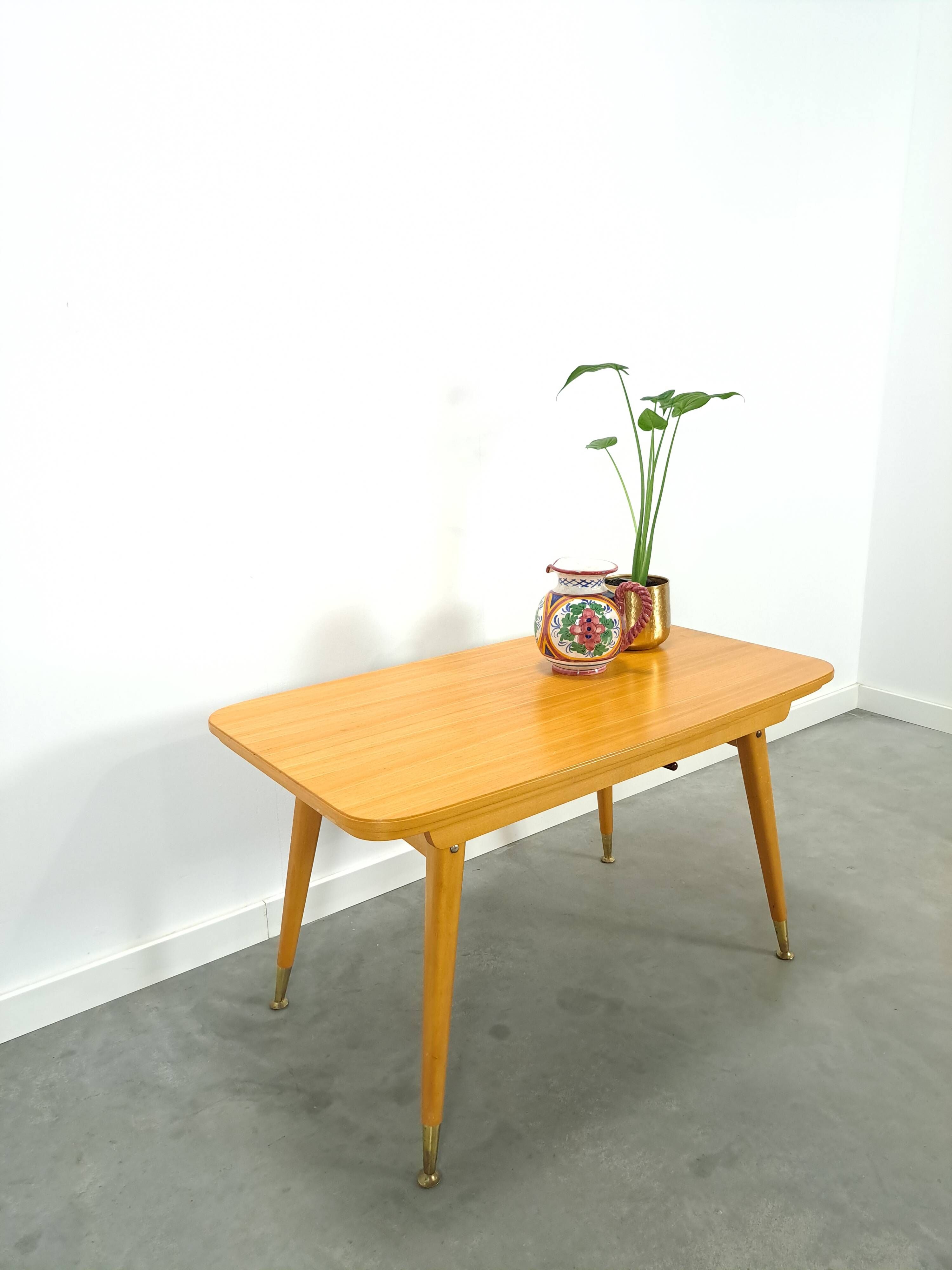 Vintage veneer table with pretty angular legs and brass at the base of the legs.