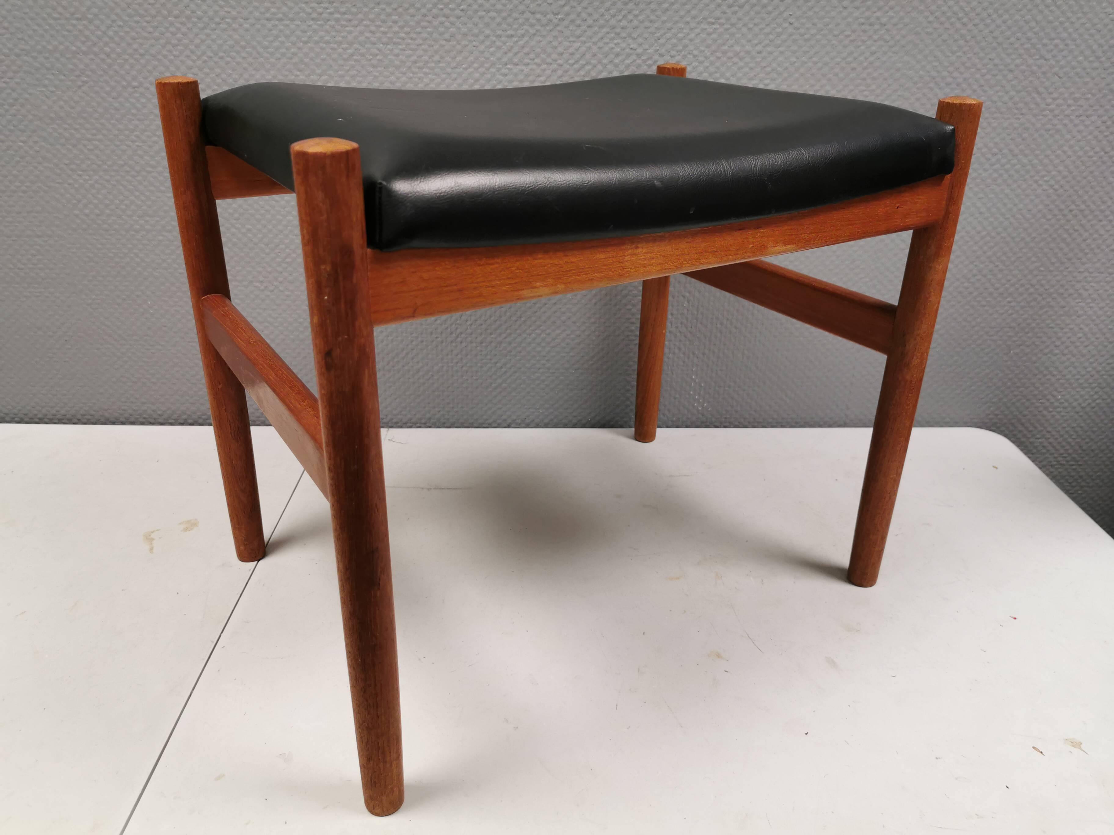 Danish designed footstool in teak wood and black skai “imitation leather”