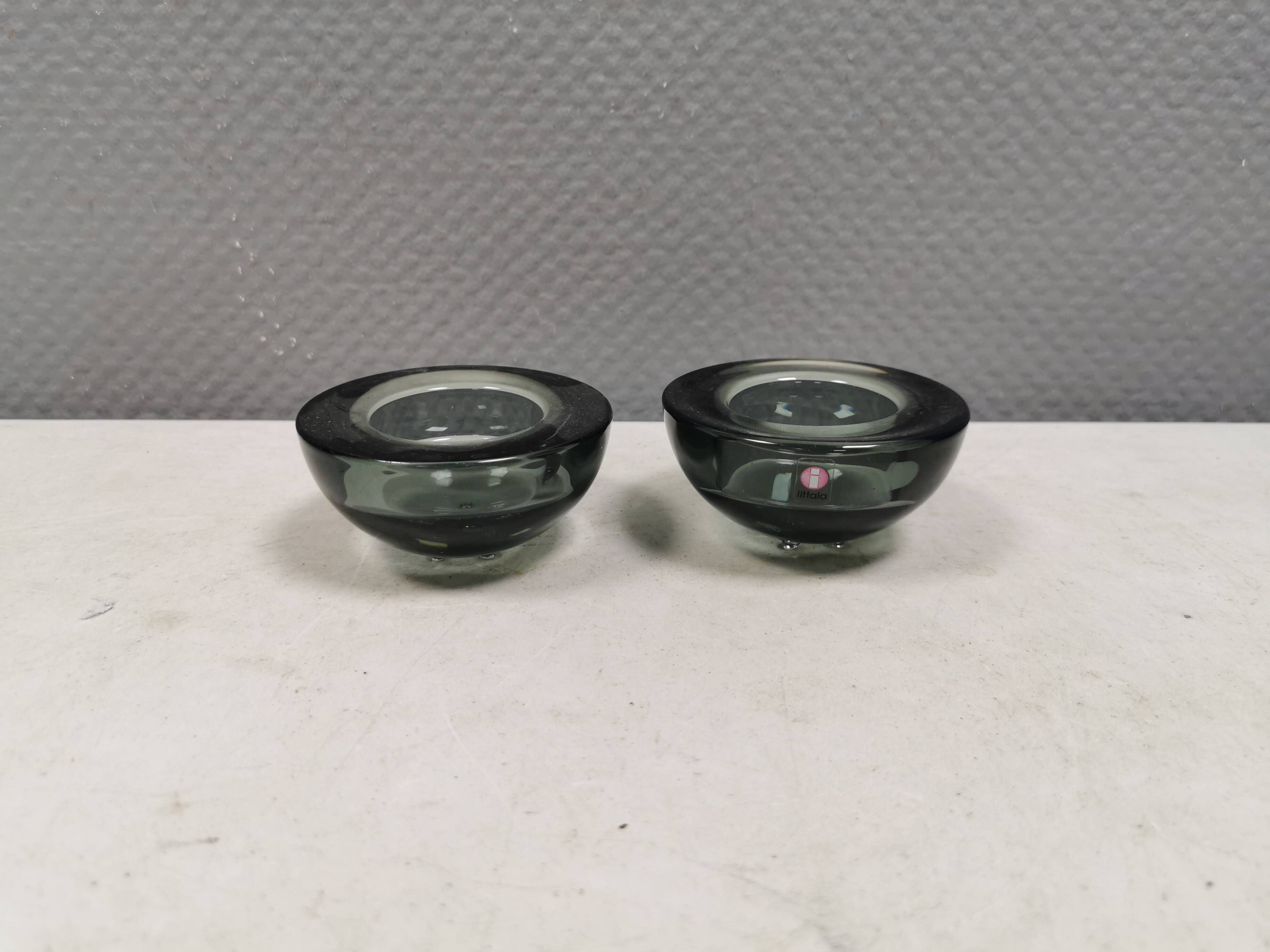 Un ensemble de porte-bougies iittala en verre transparent fumé.
