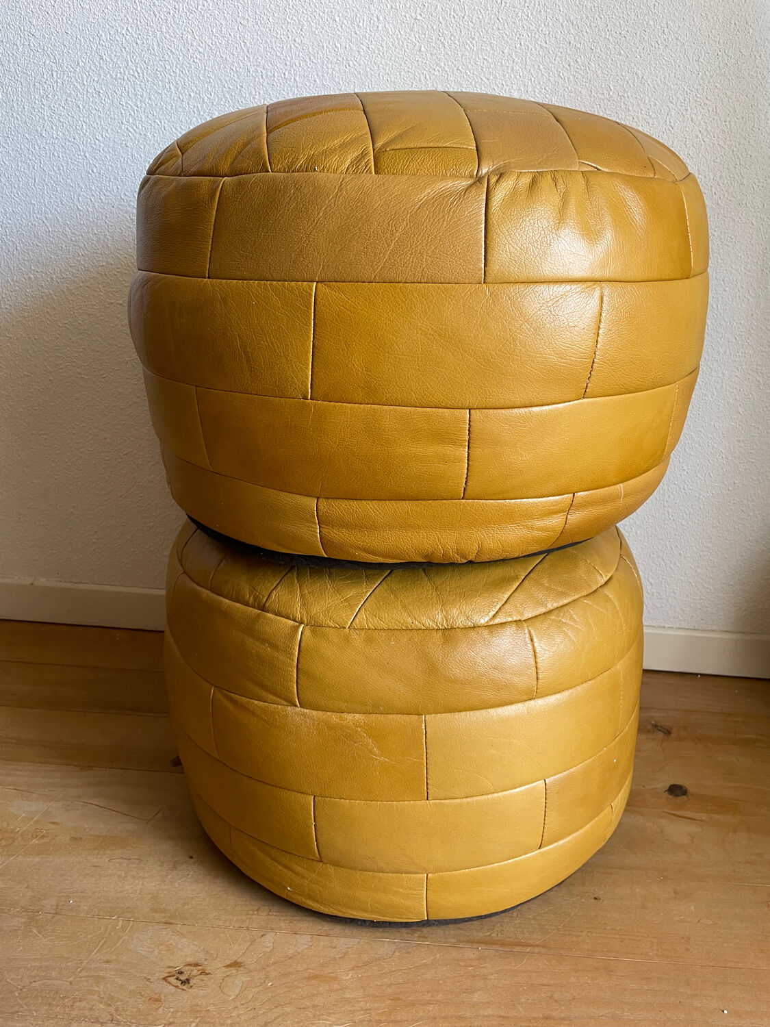 2 poufs moutarde patchwork en cuir de Sède