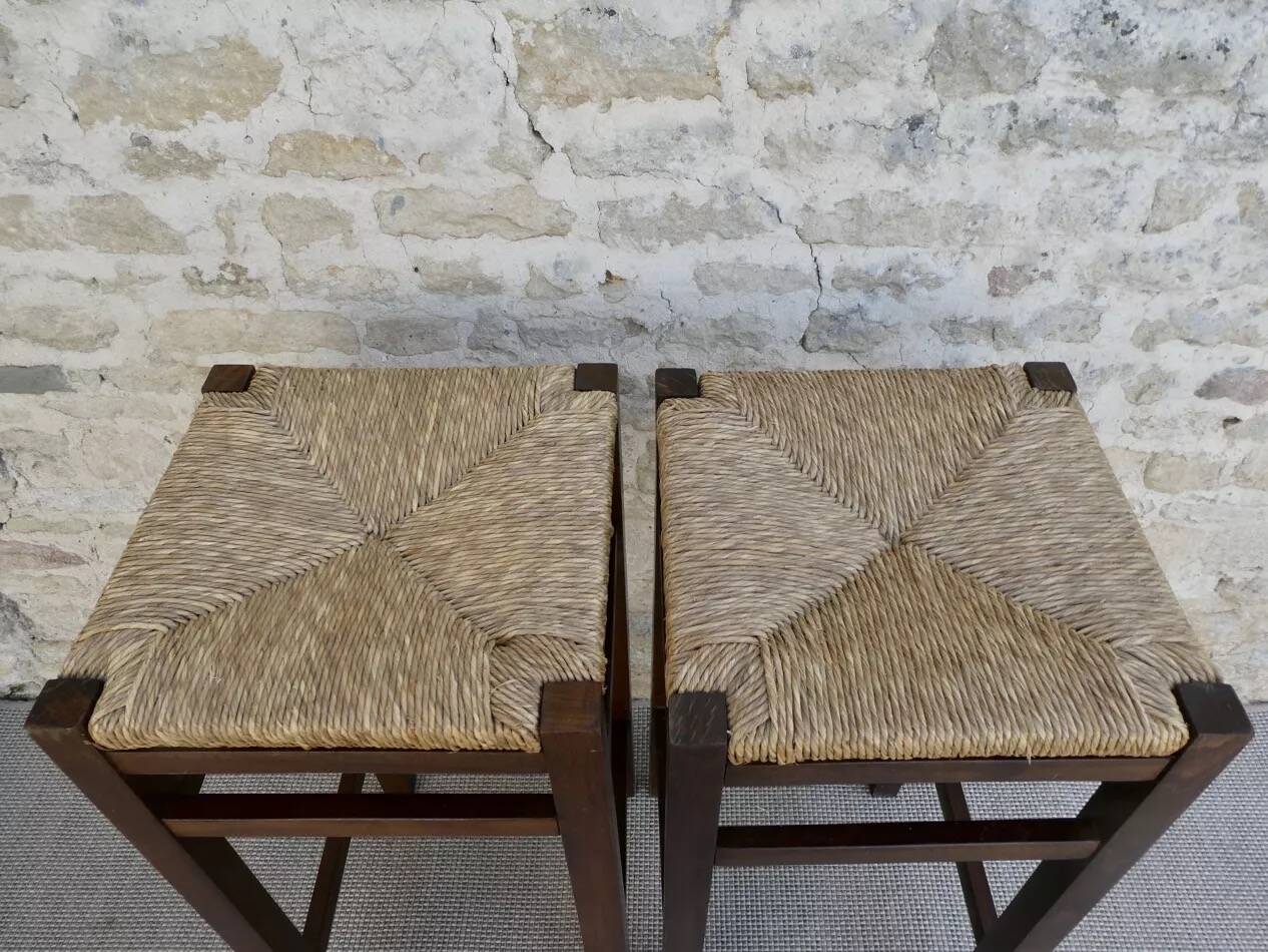 pair of bar stools, made of wood with a straw seat