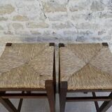pair of bar stools, made of wood with a straw seat