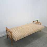 Canapé-lit beige rayé avec cadre en bois