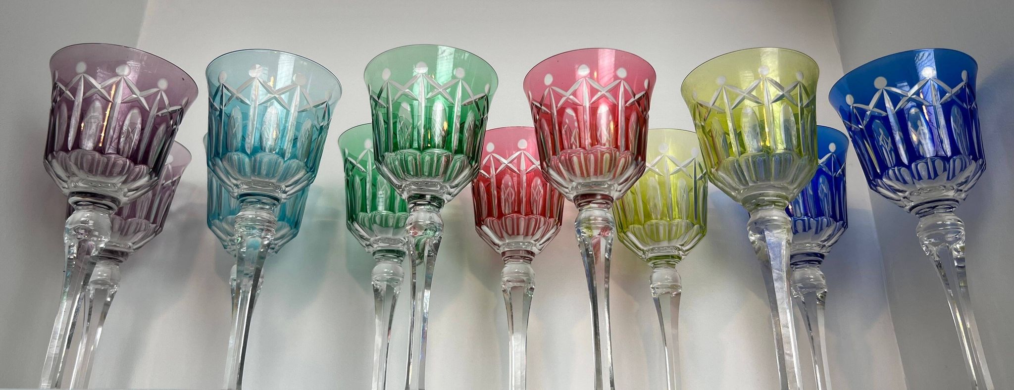 Set of twelve glasses in crystal tinted in different colours and cut with stars.