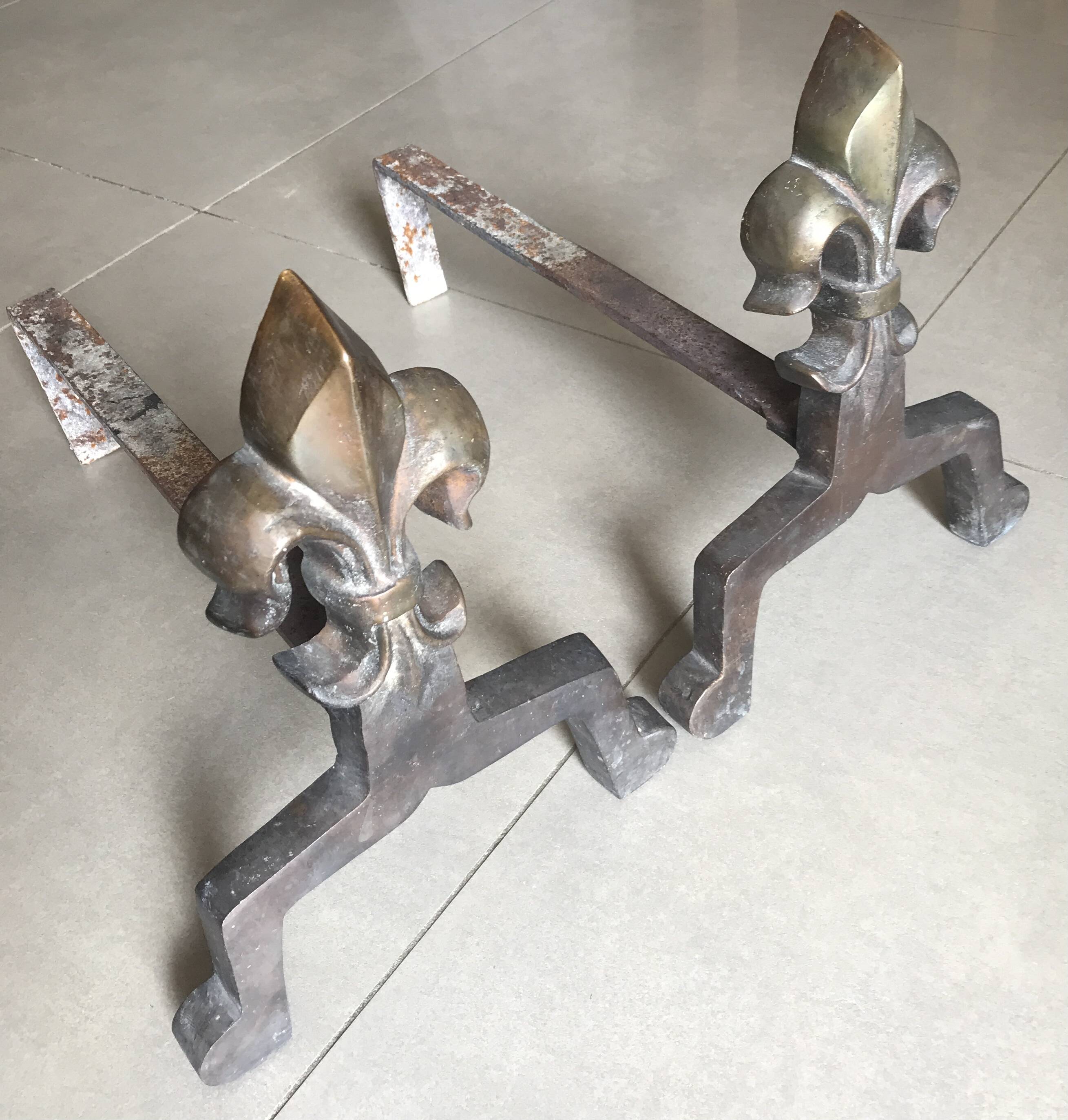 Pair of bronze fireplace firedogs with fleur-de-lys decor, art deco