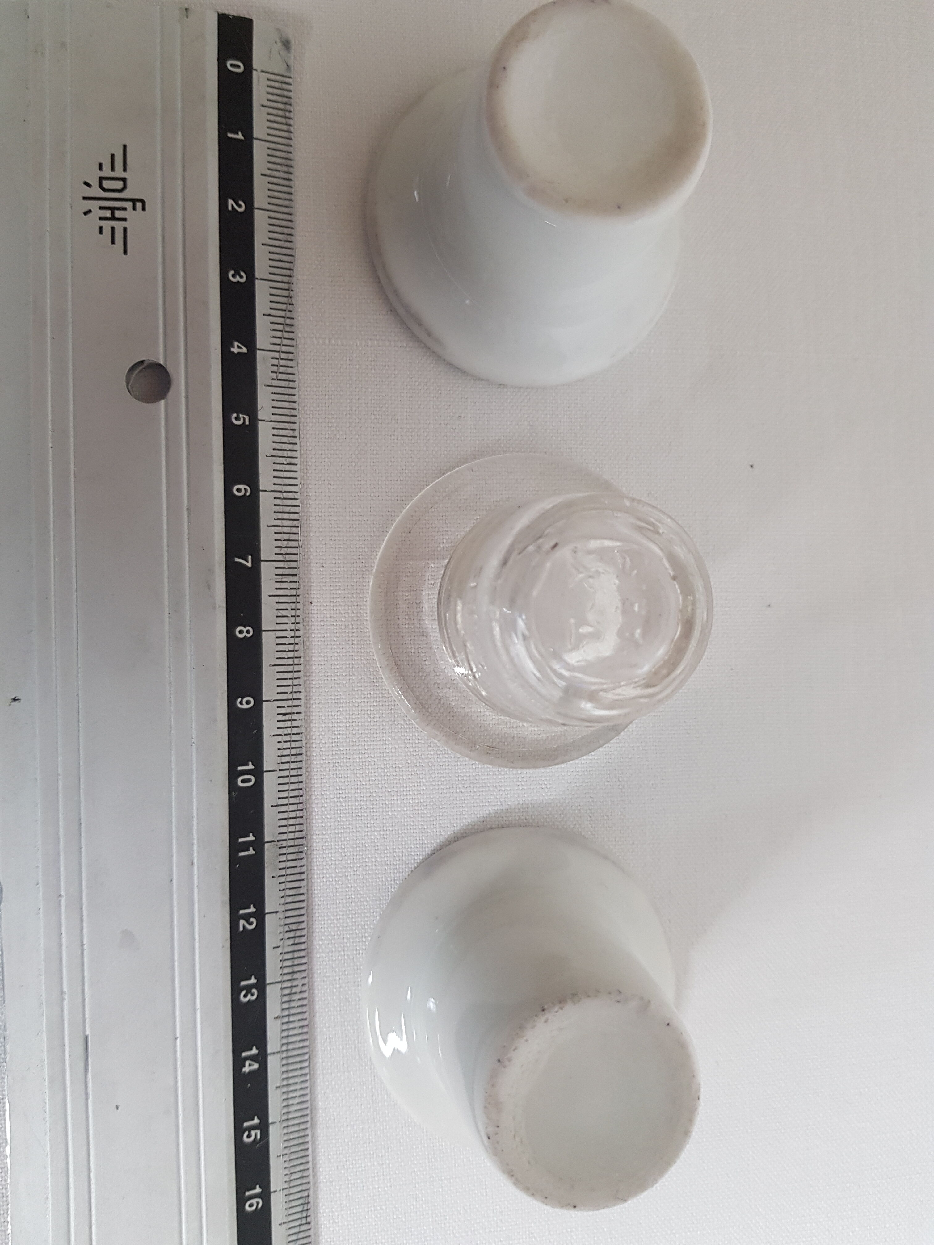 Three white porcelain and glass inkwells for school desk