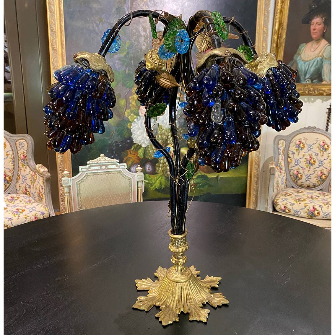 Table lamp with four light arms and globes shaped like bunches of grapes.