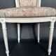 Antique Louis XVI style chair with patinated wood and floral fabric.