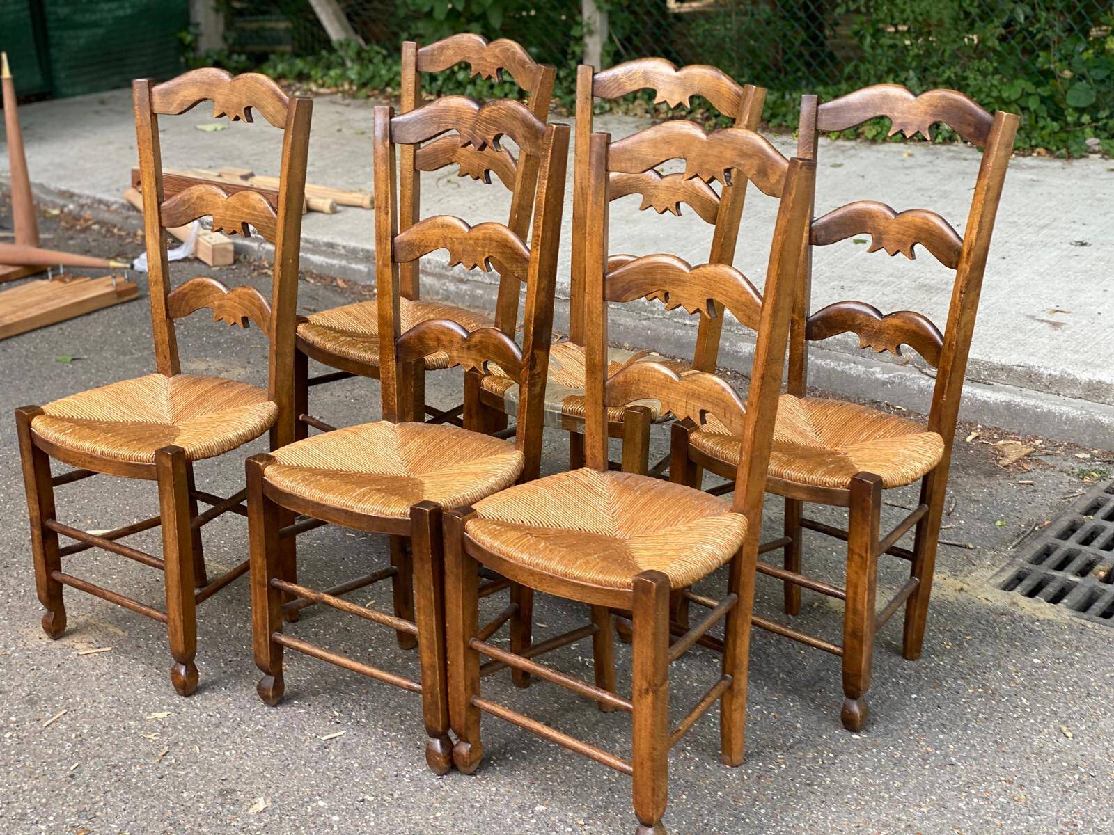 6 solid wood chairs with straw seats and butterfly carved backs.