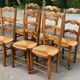 6 solid wood chairs with straw seats and butterfly carved backs.