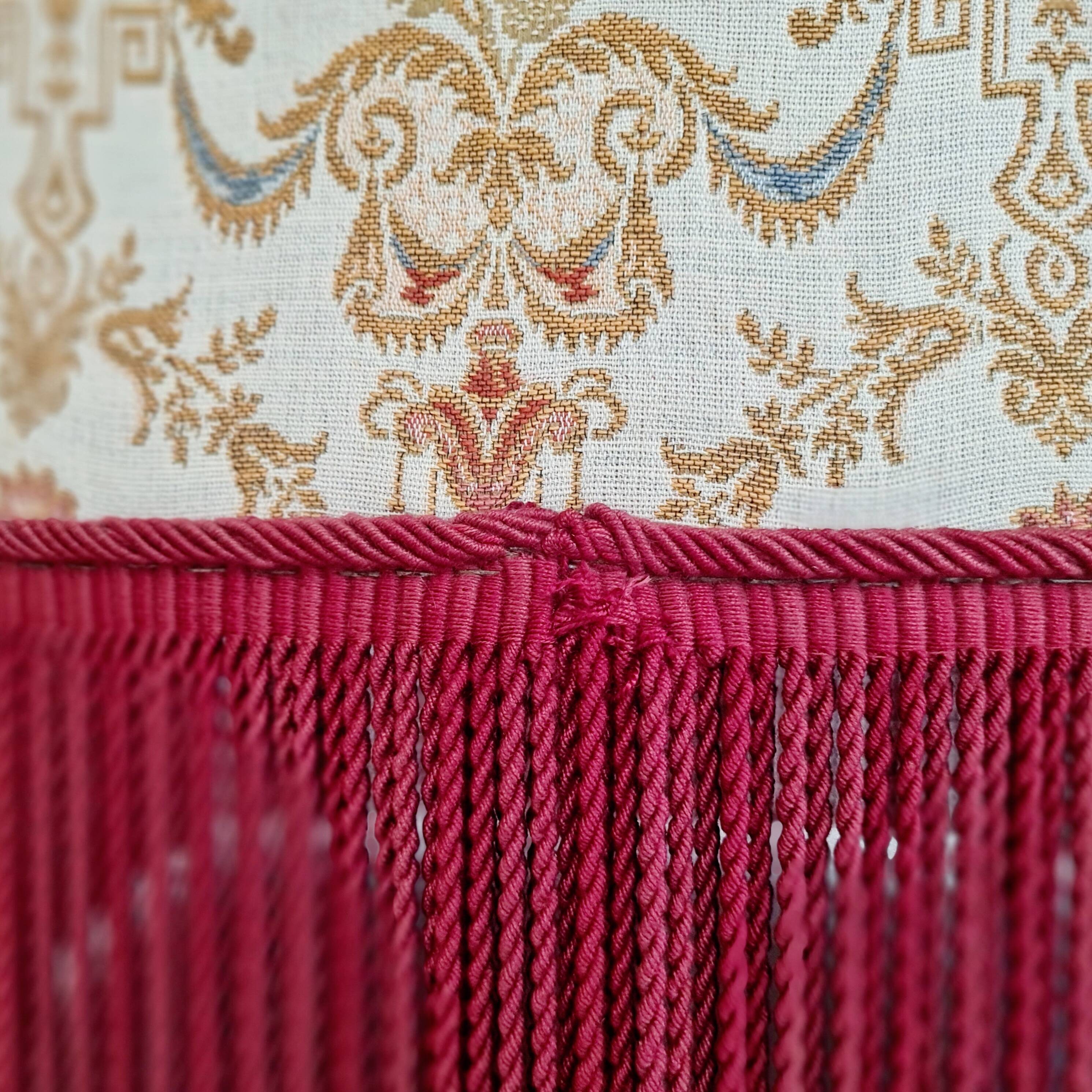 Beige toad armchair with floral patterns and red fringes