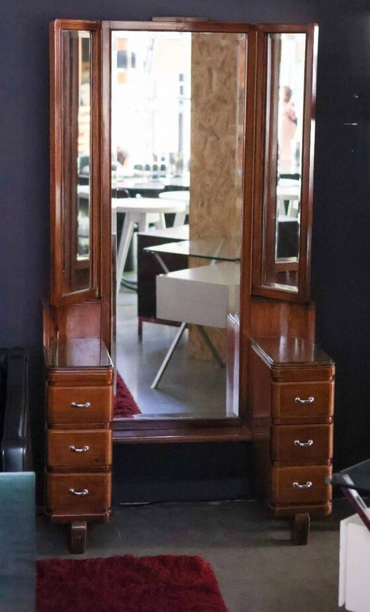 Hairdresser with a large shaped mirror and two pivoting side mirrors.