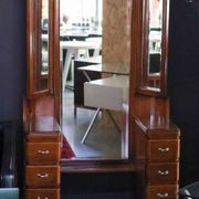 Hairdresser with a large shaped mirror and two pivoting side mirrors.