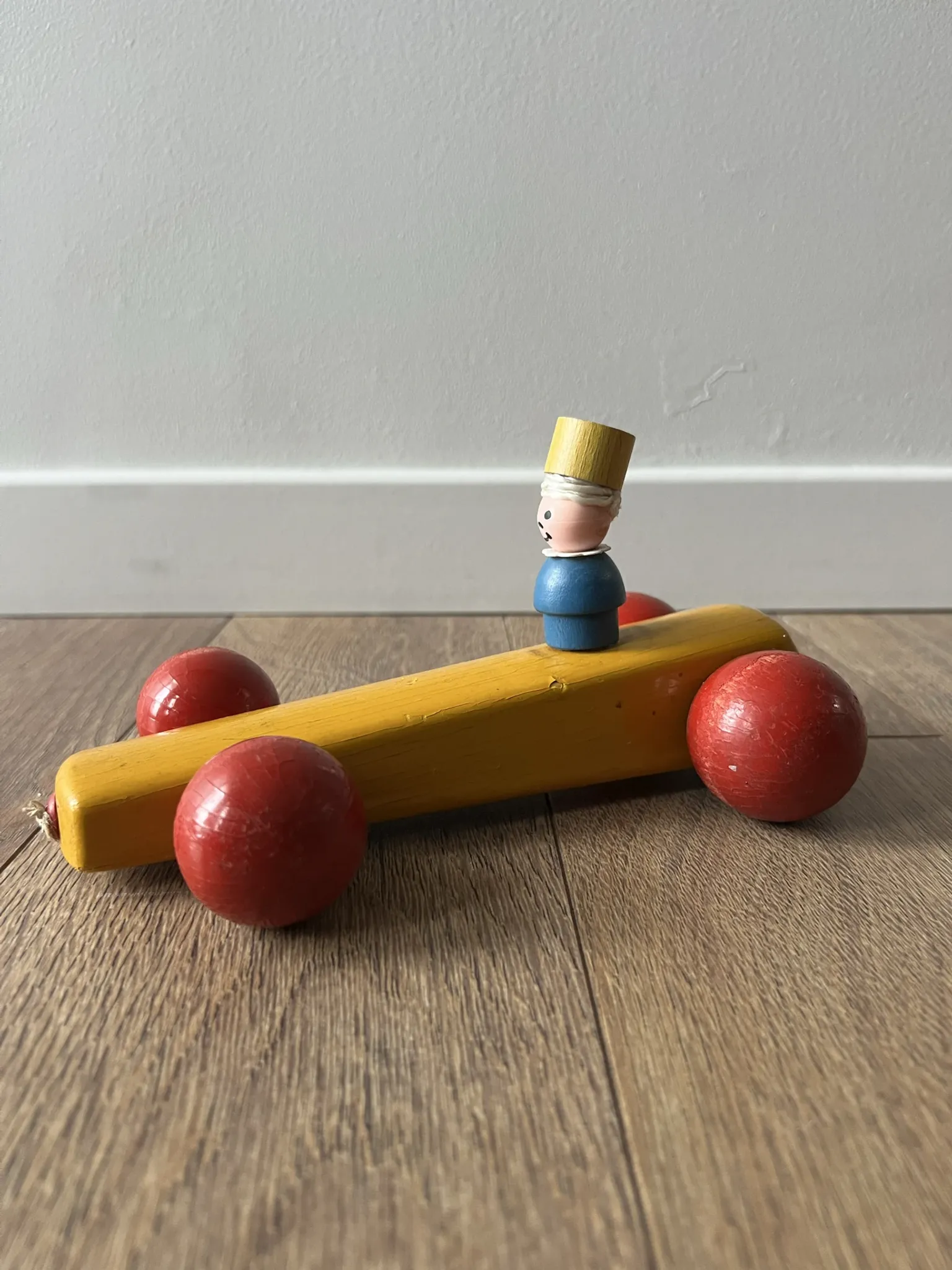 Vintage wooden pull toy, yellow car and small soldier.