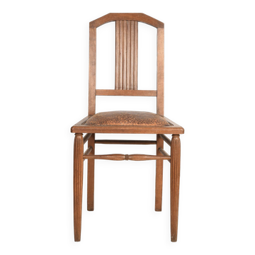 Art Deco style chair in carved wood and leather.
