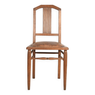 Art Deco style chair in carved wood and leather.