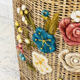 Vintage wicker mannequin with colourful floral decoration.