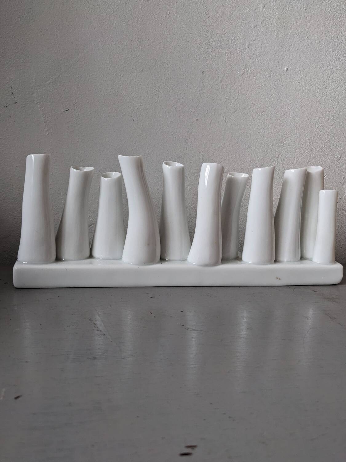 set of decorative vases composed of 11 white ceramic soliflores, evoking the delicate appearance of coral. In good general condition, despite some chips. Dimensions: 29.5 * 5.2 * 11.5 cm.