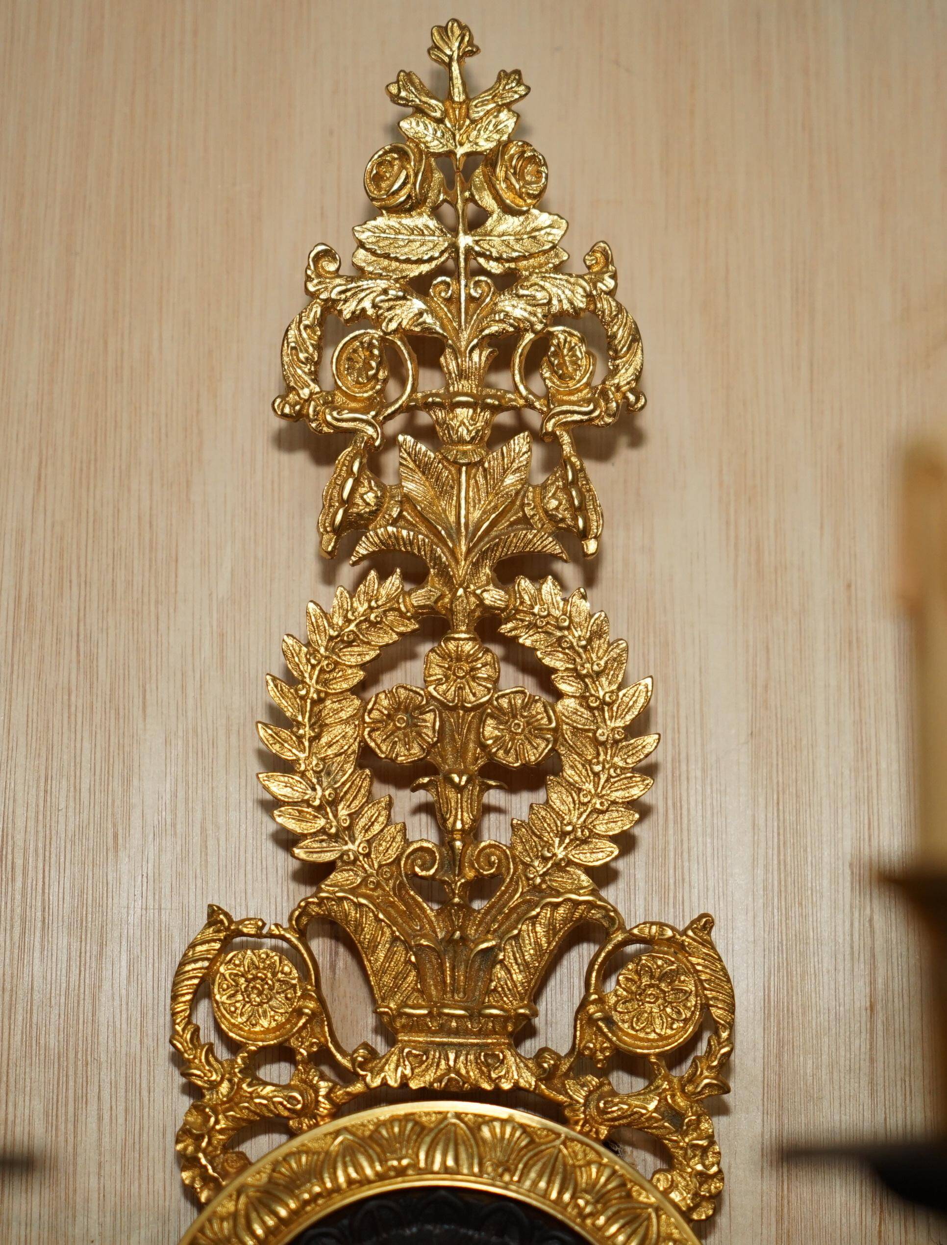 Pair of L'Originale wall sconces plated with 24-carat gold featuring four bronze candles.
