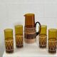 Vintage service for orangeade in amber glass and wicker.