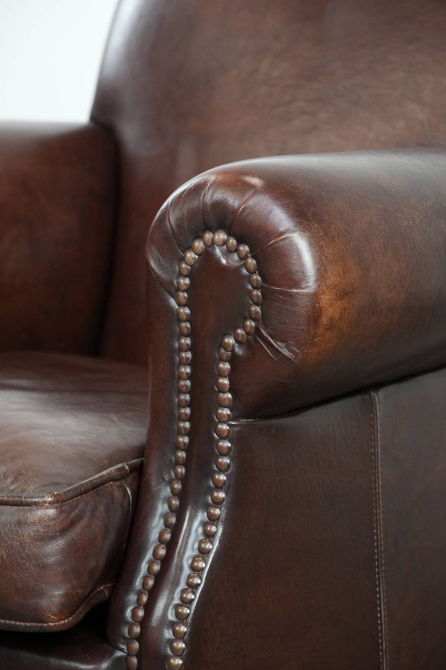 Sheepskin armchair with a classic finish and decorative studs.