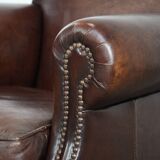 Sheepskin armchair with a classic finish and decorative studs.