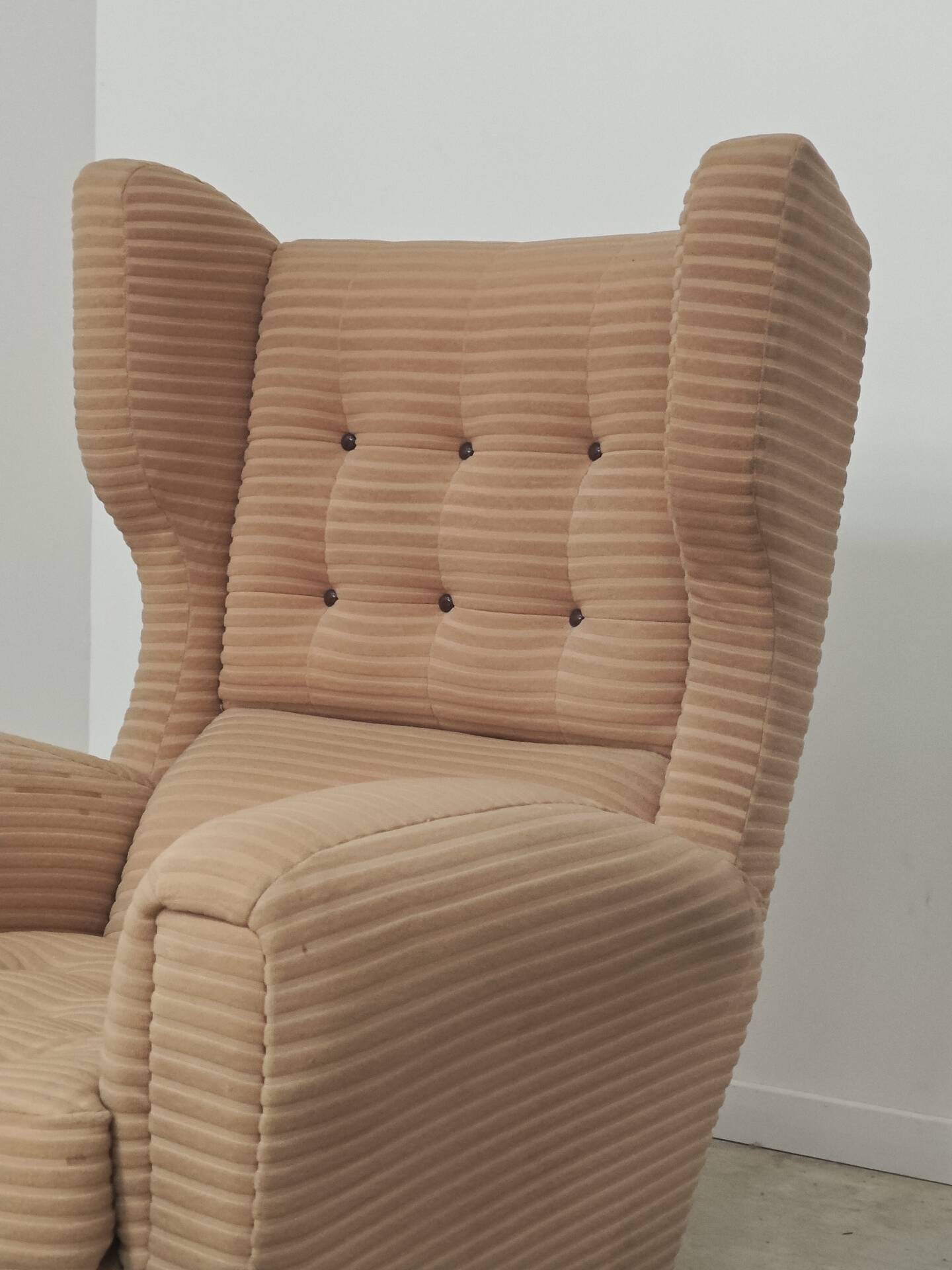Beige wingback armchair and TVAR footrest, former Czechoslovakia.