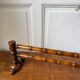 Wall-mounted coat rack made of turned wood in a bamboo style.