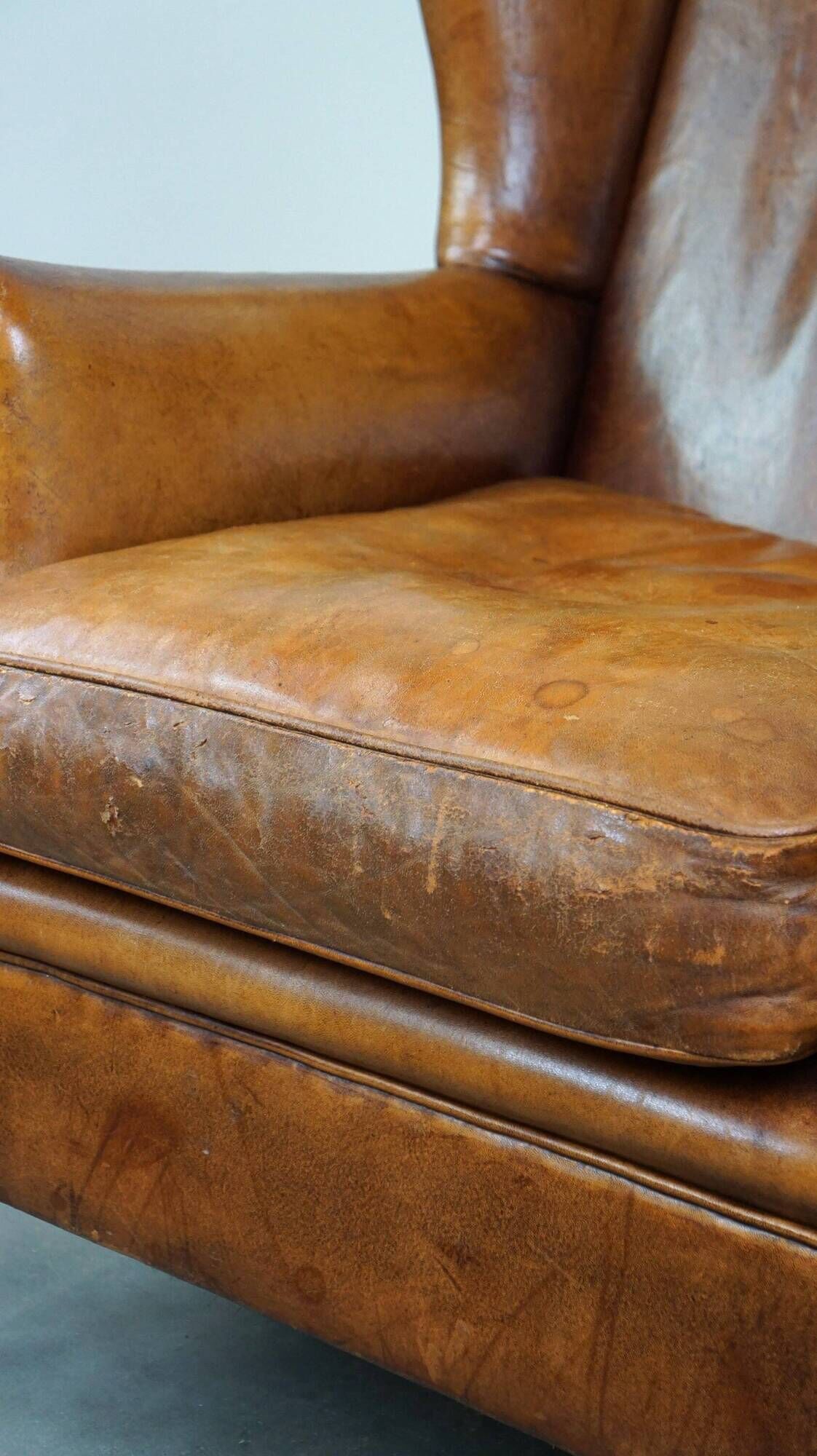 Positively lived-in sheepskin leather wing chair with pleasant seating comfort