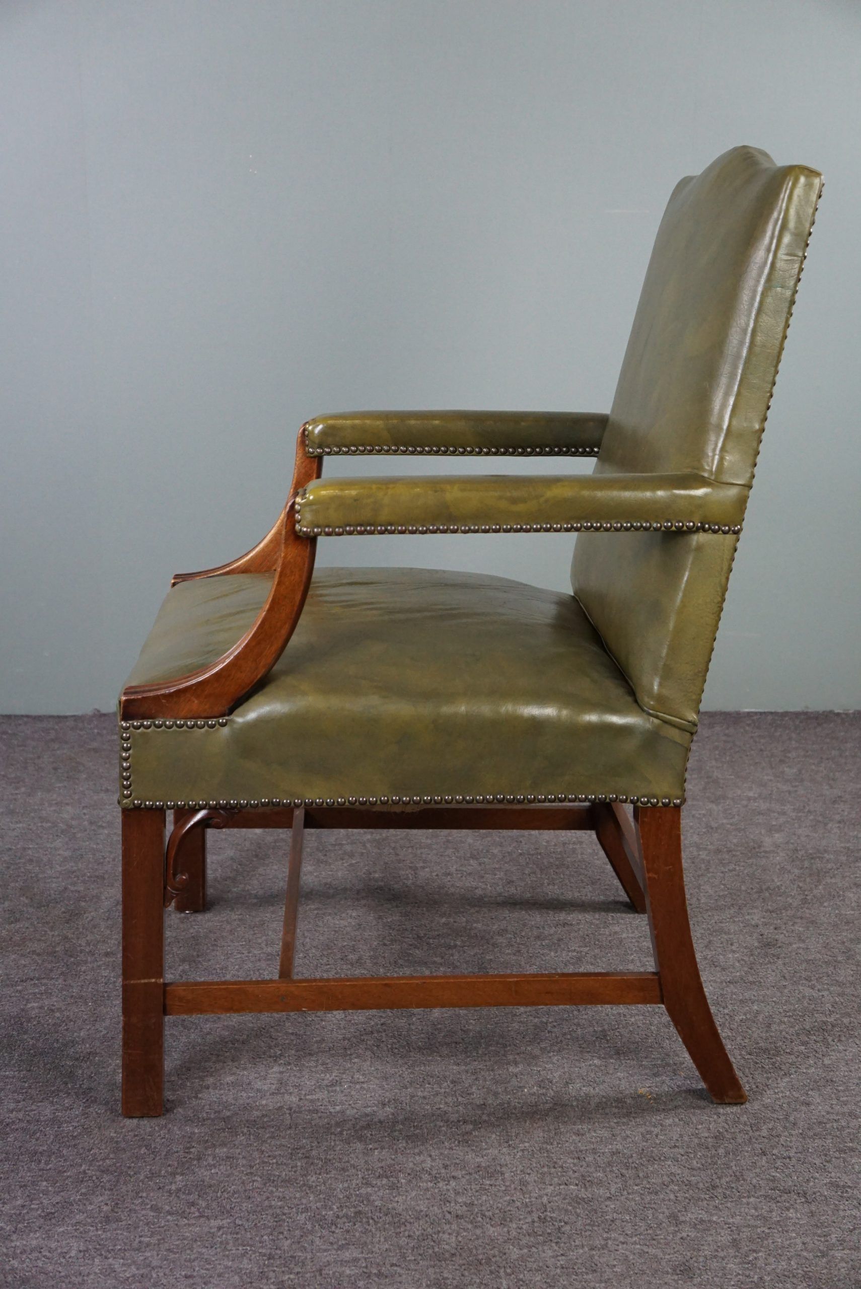 Elegant armchair and footrest in English green leather