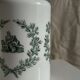 A pair of white glass bottles with Italian green patterns.