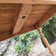 Folding drop-leaf table made of raw solid wood.