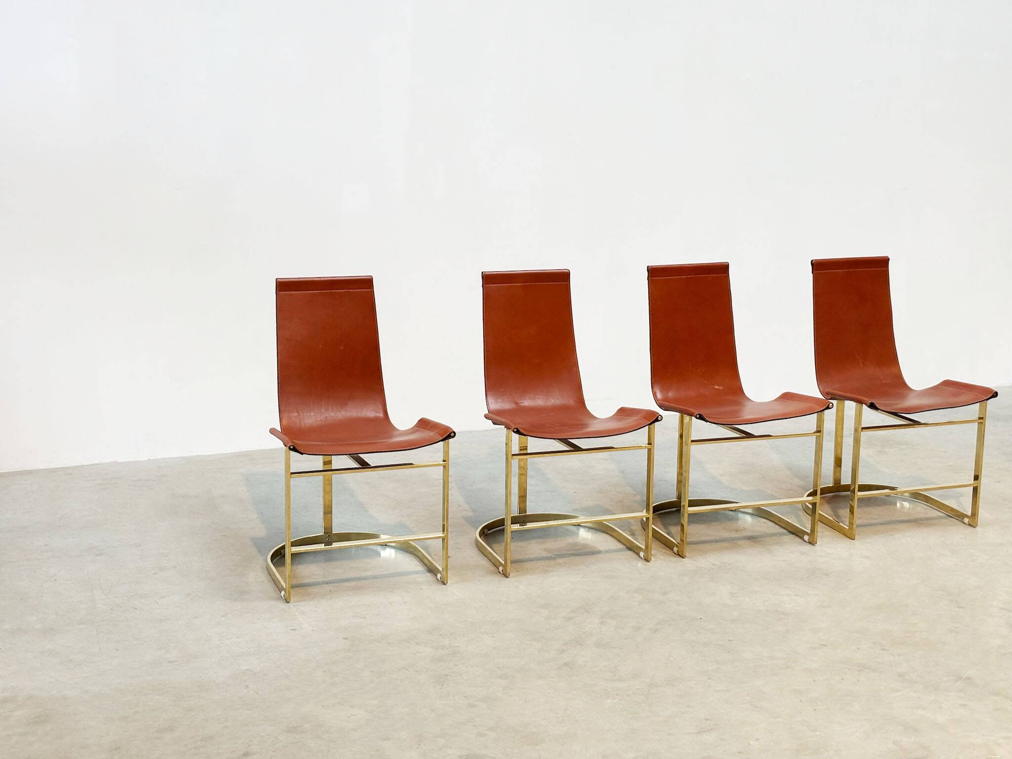 Set of four leather and brass Italian dining chairs