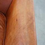 Cognac-colored cow leather club chair finished with decorative nails in English style
