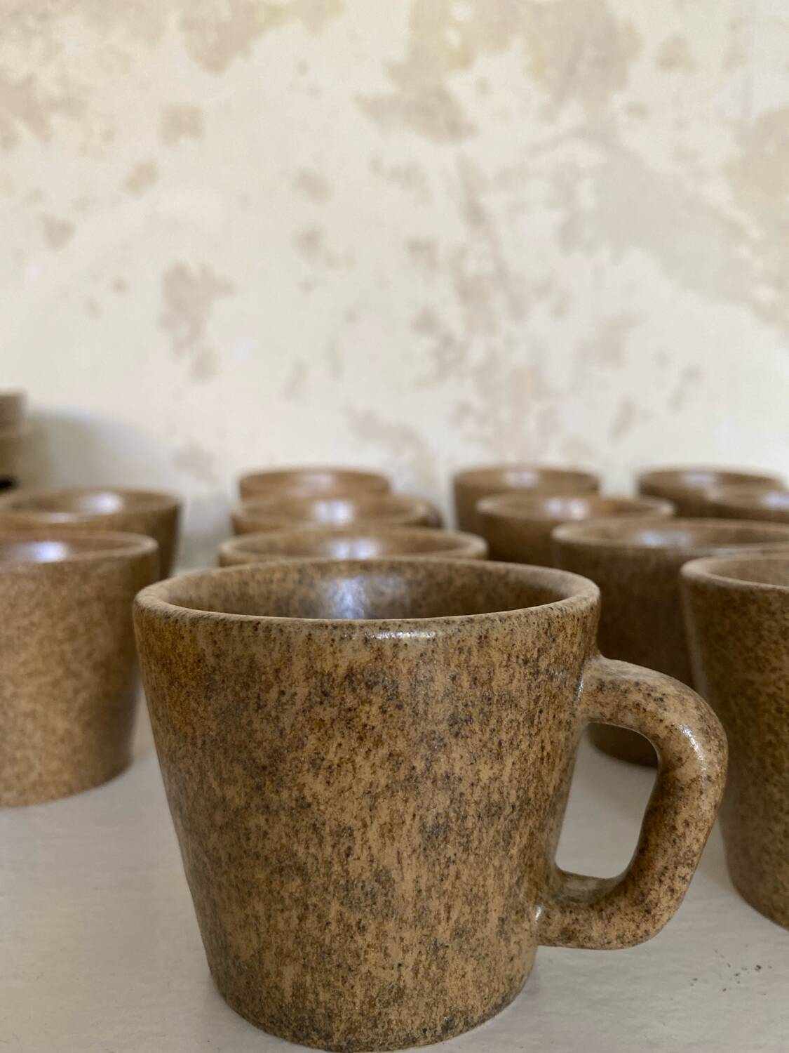 Set of stoneware coffee cups with saucers