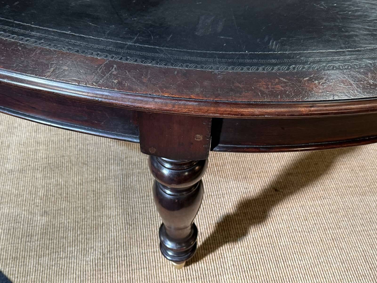 Large English library table in dark walnut with a leather top.