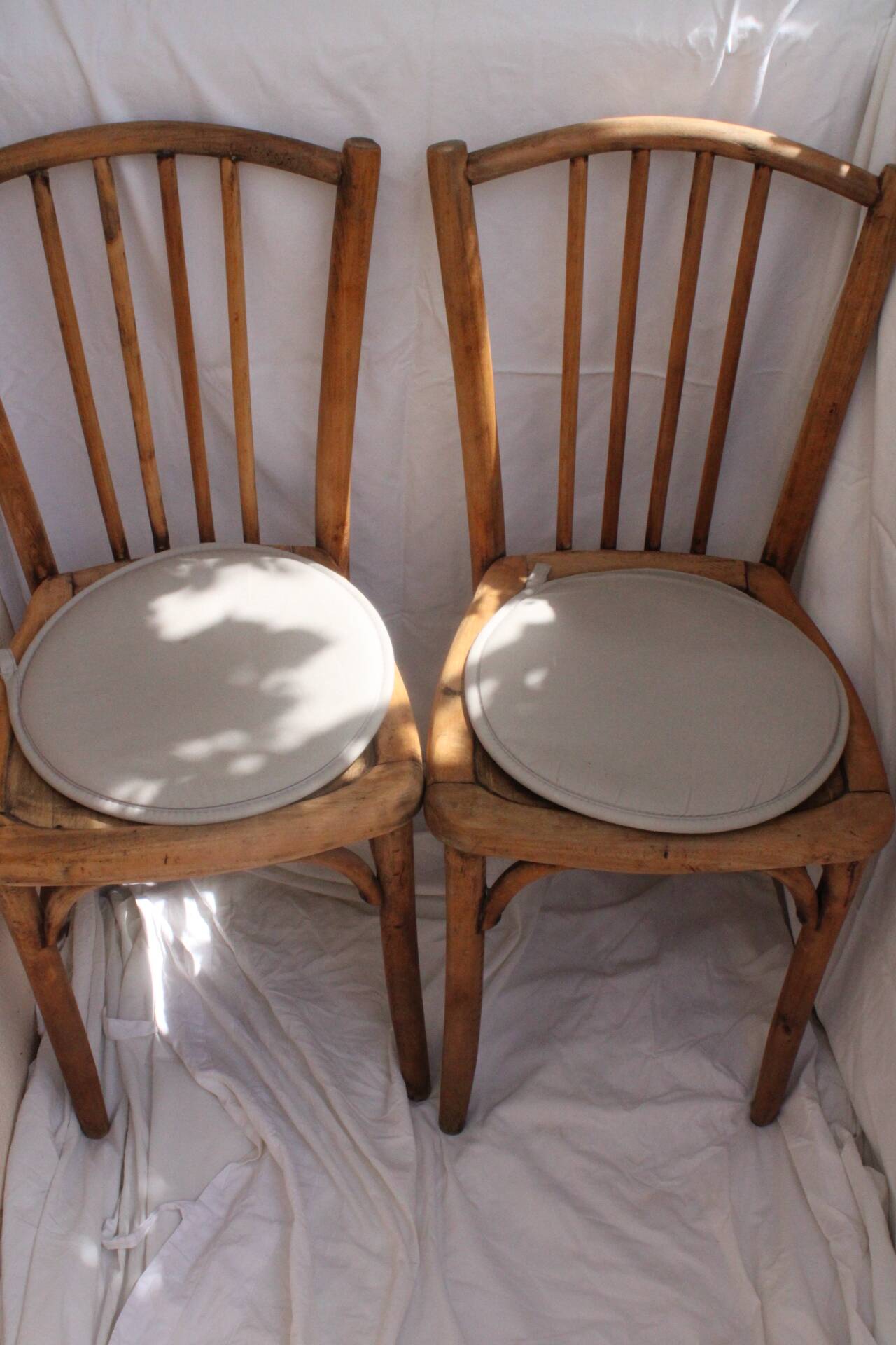 Duo of bistro chairs in bare wood, fully sanded and curved wooden backrest