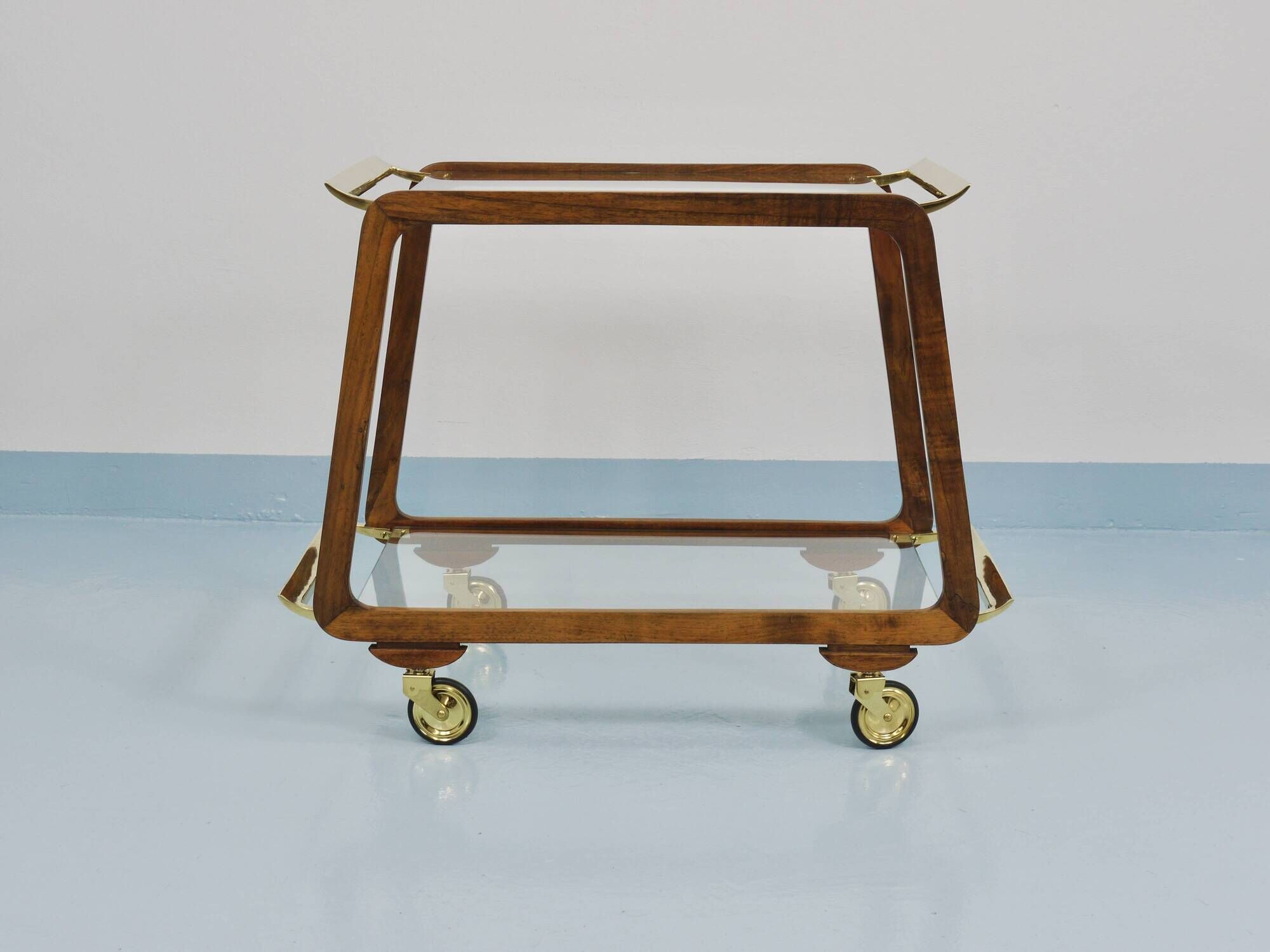 May include: A mid-century modern bar cart with a dark wood frame and two c