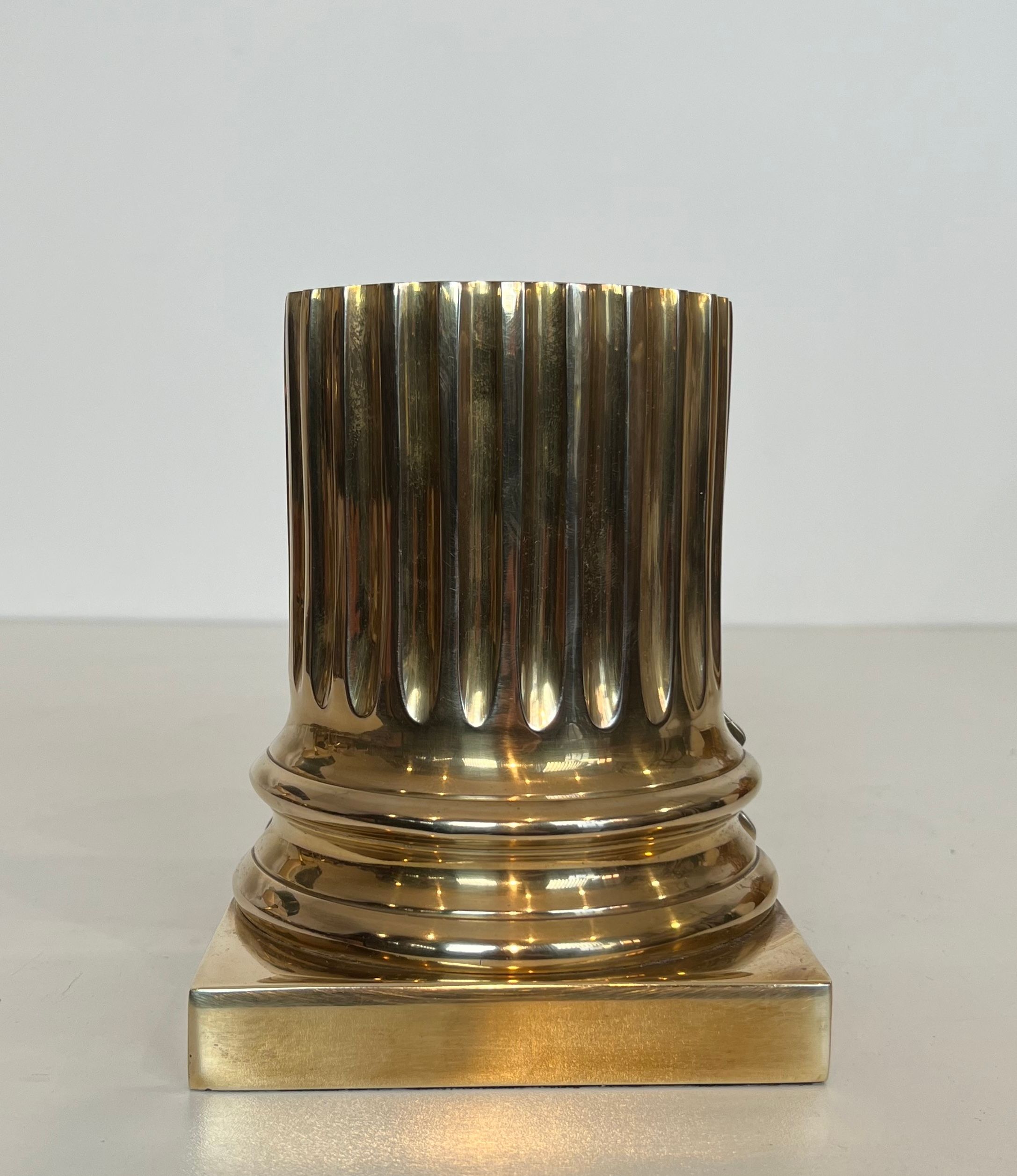 A pair of brass bookends representing columns.