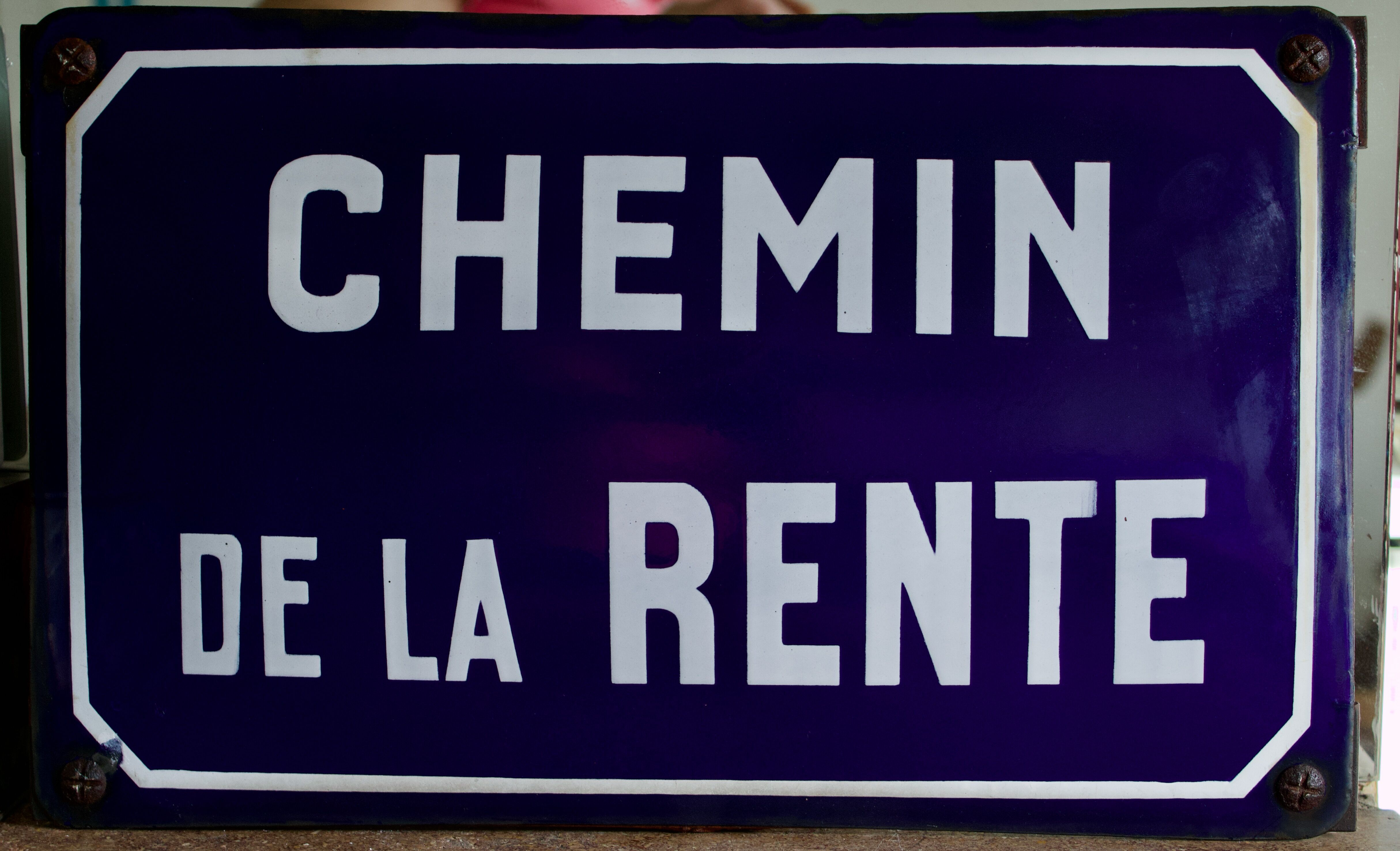 Old Enamelled and bulging "Chemin de la Rente" street plate, in perfect condition, on its cast iron support