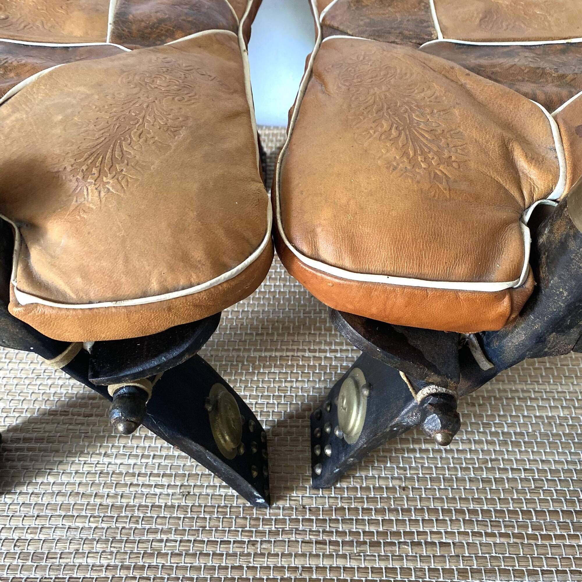 Pair of low Egyptian stools, camel saddles in wood, leather and brass