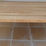 Large natural wood table with rectangular top supported by legs
