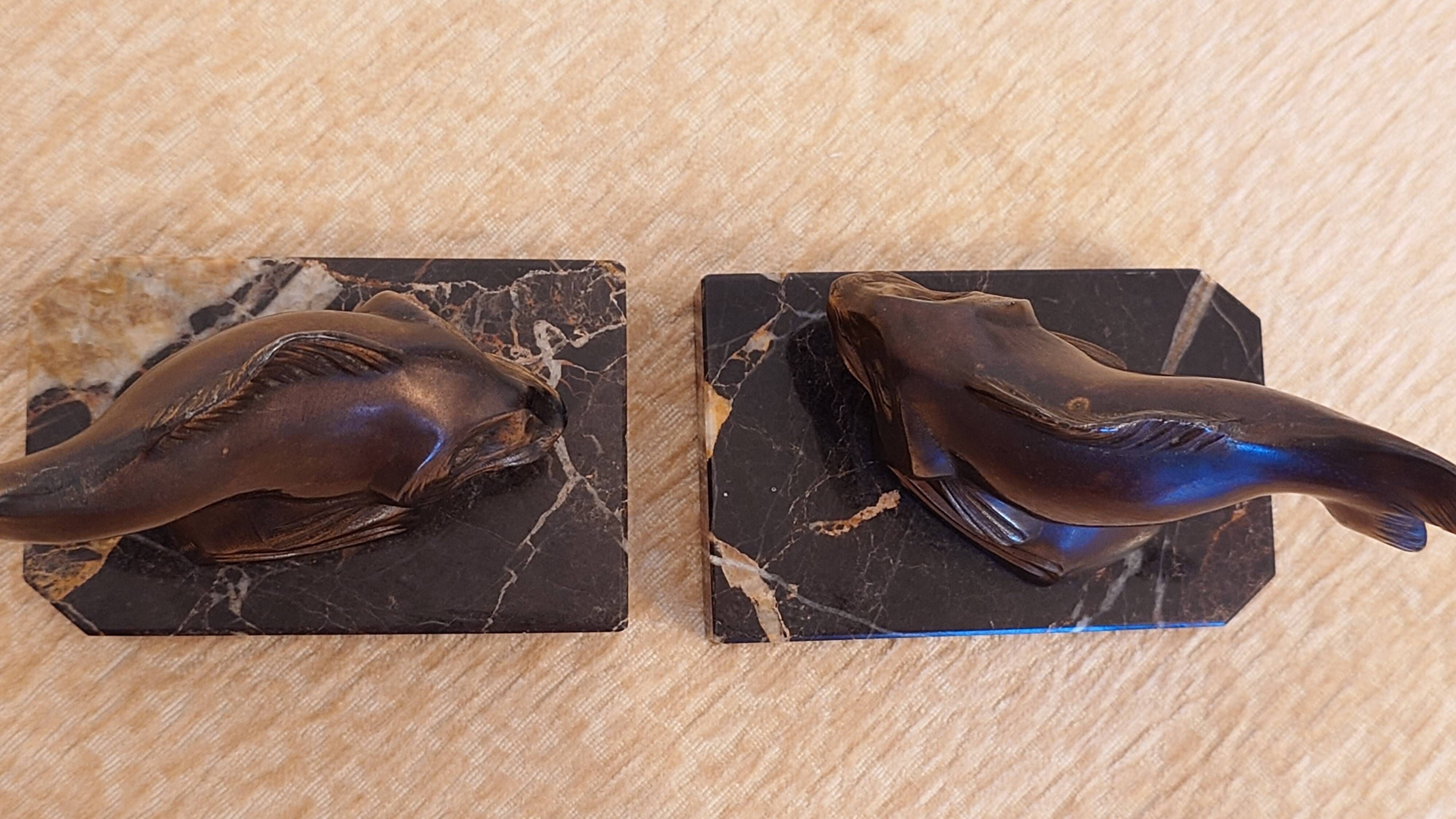 Art Deco pair of bookends with stylised fish in patinated metal and marble.