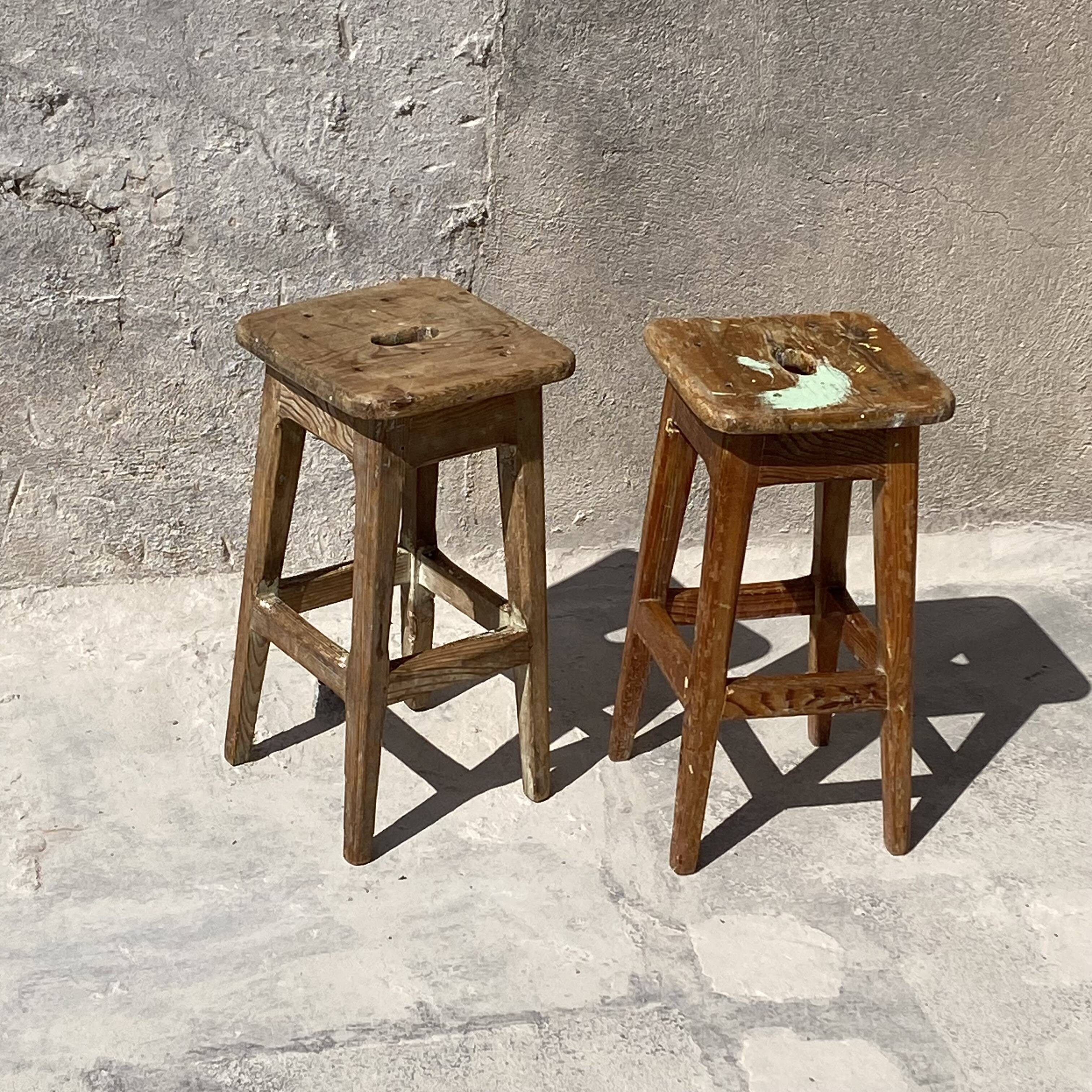 Pair of vintage wooden workshop stools with a patina.