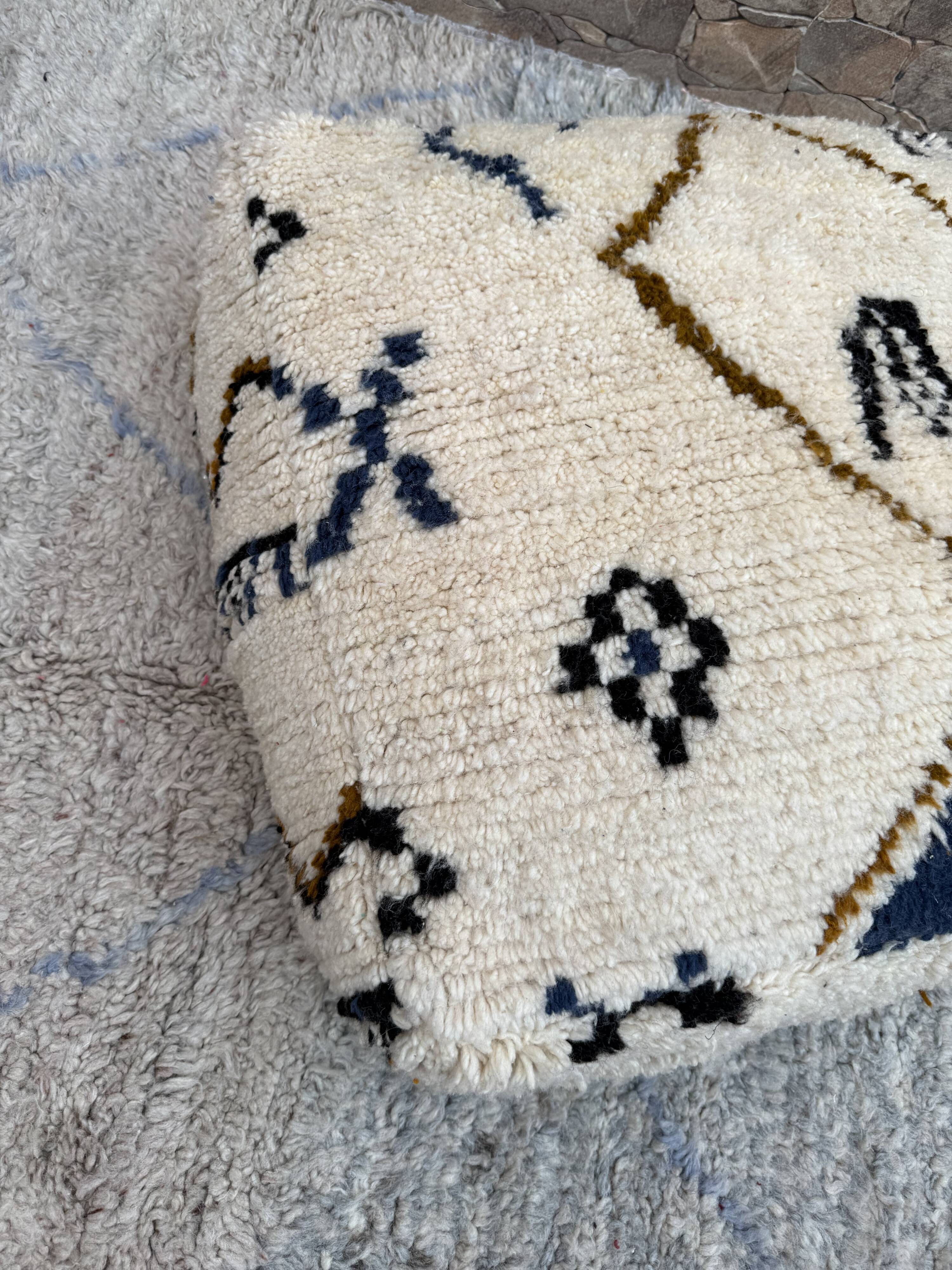 Berber floor pouf: Handwoven Moroccan wool cushion.