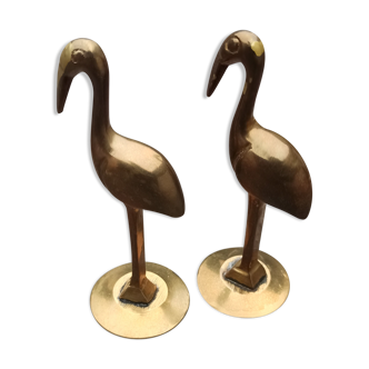 Two pink flamingos in old brass